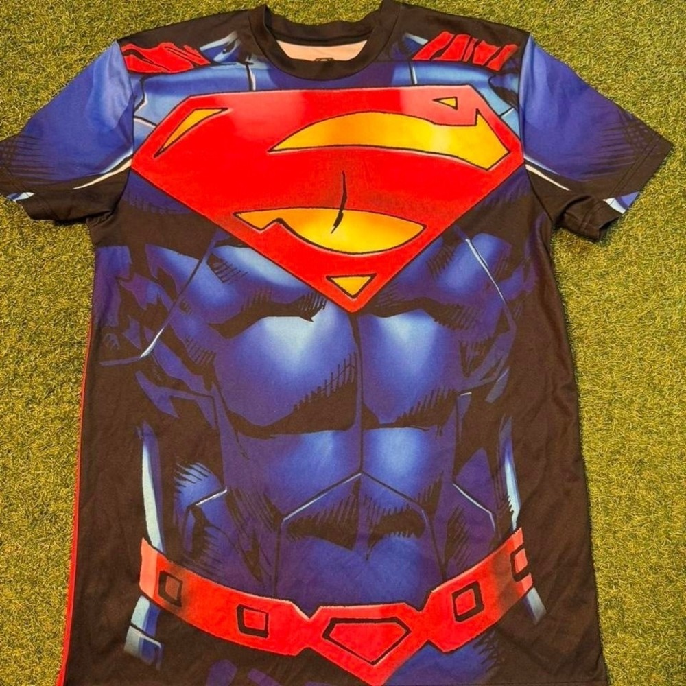 Superman all-over print graphic tee. Features bold chest logo with muscle print